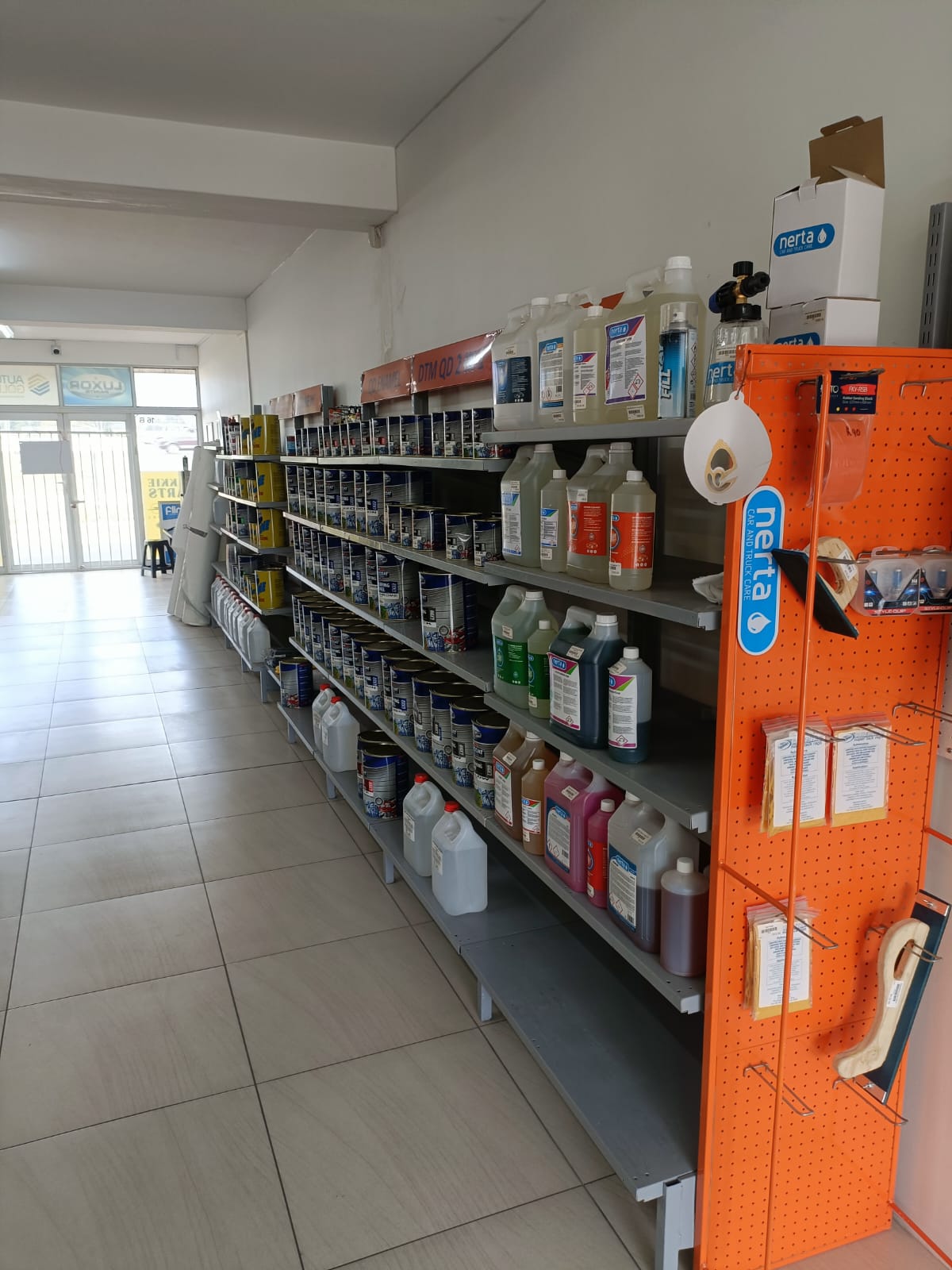 Aisle with thinners, detailing products, and paint supplies inside the store